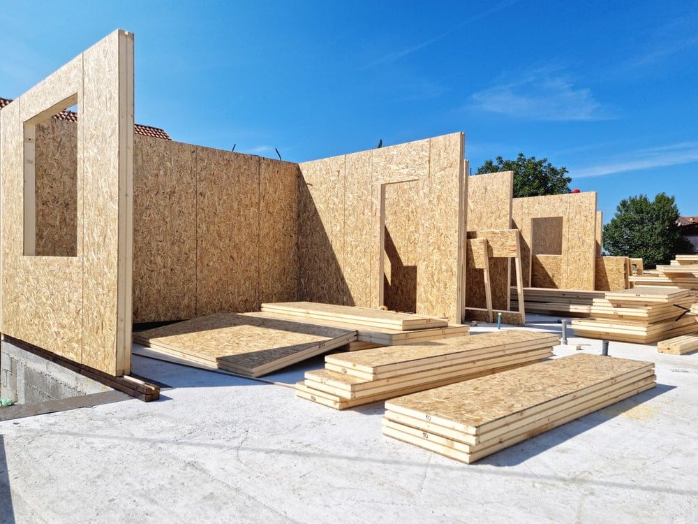 Assembling a modern modular home with energy-efficient, prefabricated wood panels, highlighting sustainable construction in New Orleans.