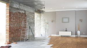 Unfinished interior of a renovation project in New Orleans, featuring brick walls and hardwood floors, highlighting the transformation in construction.
