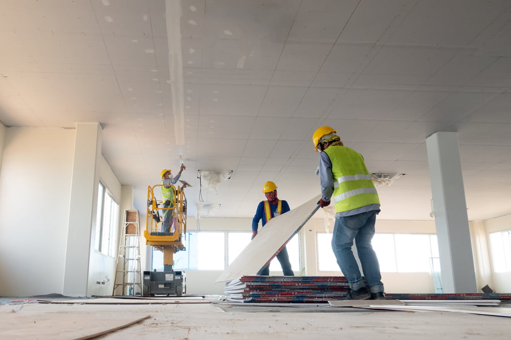 Workers installing ceiling materials during new home construction in New Orleans.