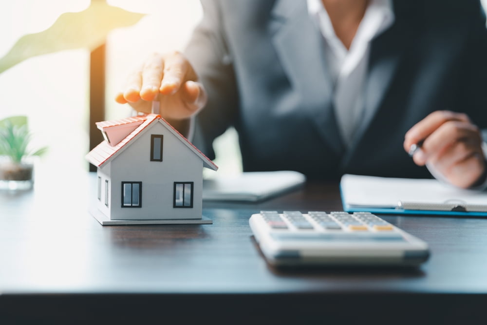 A person planning a new home construction budget with a calculator on the table. New home construction in New Orleans.