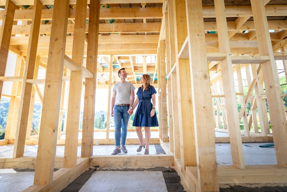 A couple embarking on their journey of new home construction, visiting a construction site to turn their dream into reality.