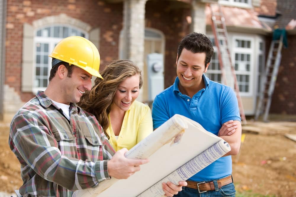 New Home Construction: Excited Couple Discussing House Plans with a man from a construction company.