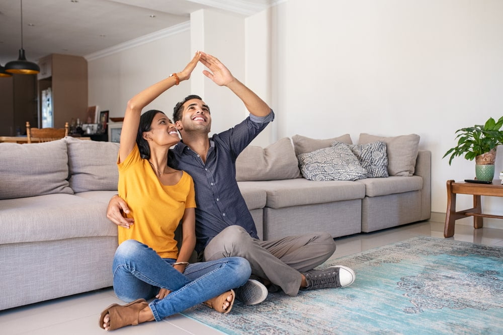 A couple sitting in the living room dreaming of a new home - nola construction companies